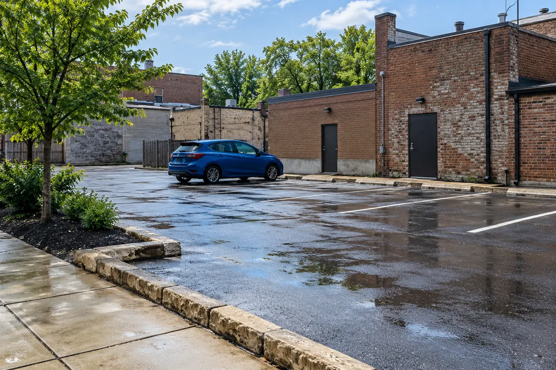 Representative Ohio downtown parking area with a parked blue car and brick buildings.